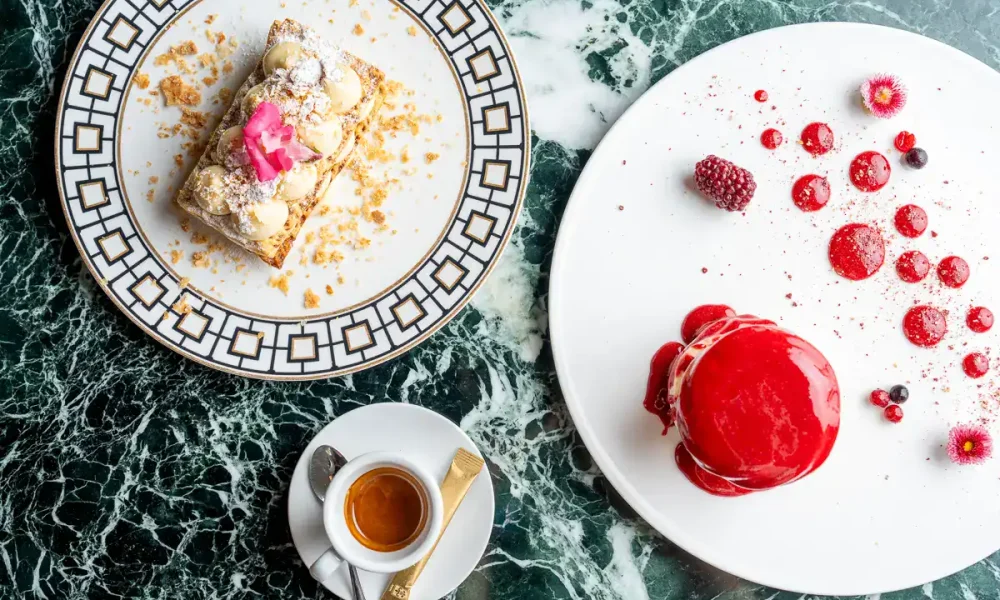 Wunderschöner Kuchenteller mit detailreicher Desserts auf grünem Marmor-Tisch, perfekt für hochwertige Kaffee- und Konditoreikreationen.